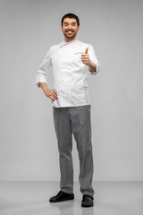 cooking, culinary and people concept - happy smiling male chef in jacket showing thumbs up over grey background
