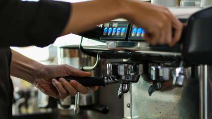 Close up shot of measuring glass filling with dark brown hot delicious good smell coffee by luxury clean steel coffee making machine in cafe with blurred background