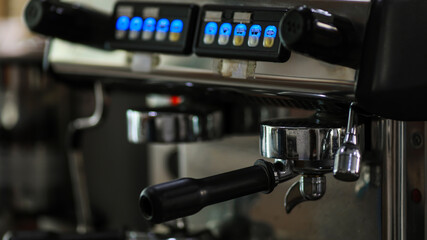 Close up shot of glass cup filled with hot delicious good smell black coffee made by barista hand from luxury coffee making machine in cafe with blurred foreground and background