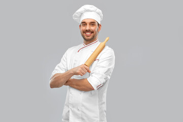 cooking, culinary and people concept - happy smiling male chef or baker in toque with rolling pin over grey background - obrazy, fototapety, plakaty