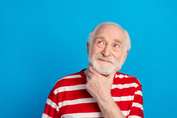 Obraz premium Photo of optimistic old grey hairdo man look empty space wear red t-shirt isolated on bright blue color background