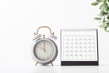 Alarm clock and calendar on white background