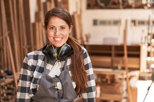 Happy young woman as a craftsman apprentice
