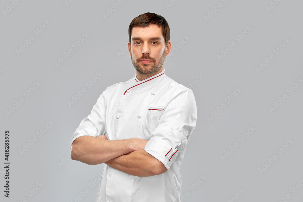 Wall mural cooking, culinary and people concept - male chef in jacket with crossed arms over grey background