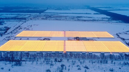 Aerial side view of large industrial greenhouses for growing plants in winter. light pollution....