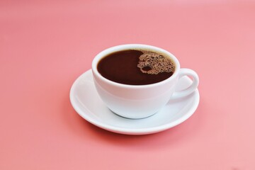 cup of coffee on pink background.