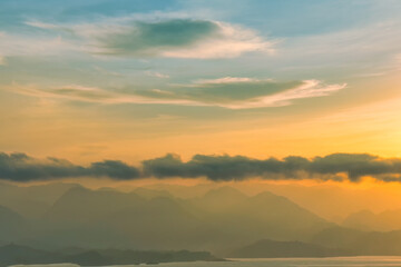 Beautiful scenery with clouds during sunrise with mountain view as background.