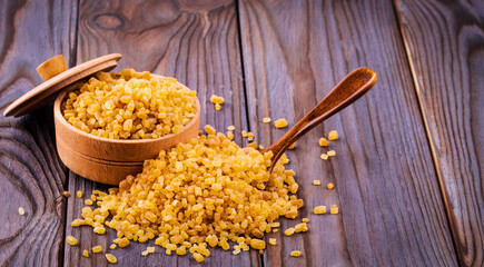 Cane sugar in a wooden cup on a wooden table.