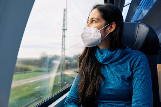 Girl With Medical Mask Looking Out The Window On The Train