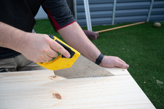 Une scie coupe une planche de bois