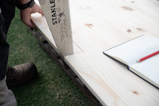 Une scie coupe une planche de bois