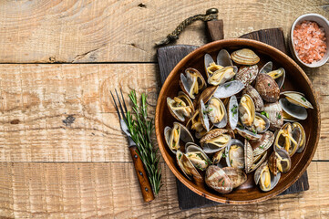 Steamed cooked shells Clams vongole in a wooden plate. wooden background. Top view. Copy space