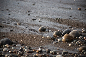 Sea shore with stones and foam, pebble seascape. 