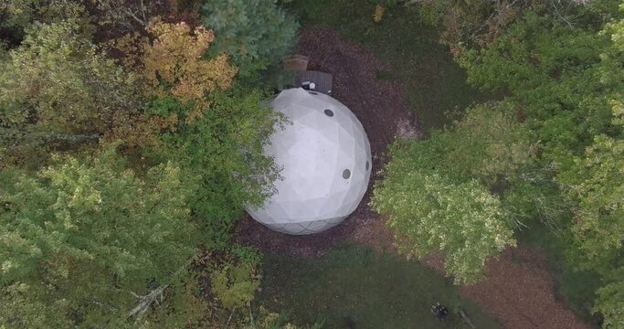 WOODRIDGE, NY, UNITED STATES - 26 SEPTEMBER 2019 - Aerial view of a geodesic dome structure in a wooded area in Woodridge, New York.