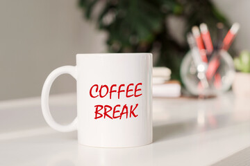 Coffee mug with text - COFFEE BREAK in workplace background.