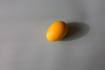 One yellow egg on a gray background with copy space. Colors of the year 2021. 