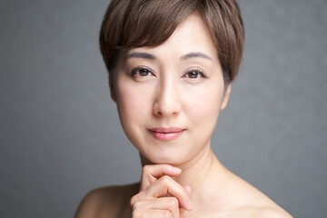 顎に手を当てる中年の日本人女性 Wall Mural Wallpaper Murals Mapo