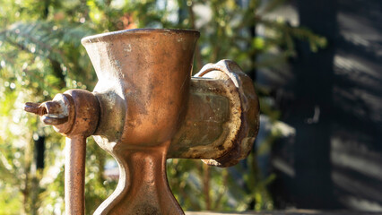 Close-up view of the old design manual meat grinder on the outdoor. Authors cuisine concept.