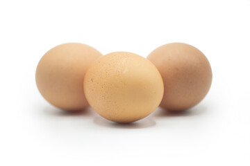 Closeup view of three brown chicken eggs put together on white background. Horizontal shot 