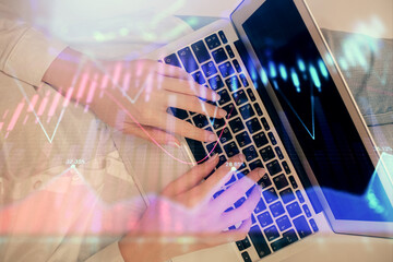 Double exposure of woman hands working on computer and forex chart hologram drawing. Top View. Financial analysis concept.