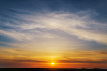 Naklejka na ściany i meble Stunning sunset with orange and blue clouds in dramatic sky