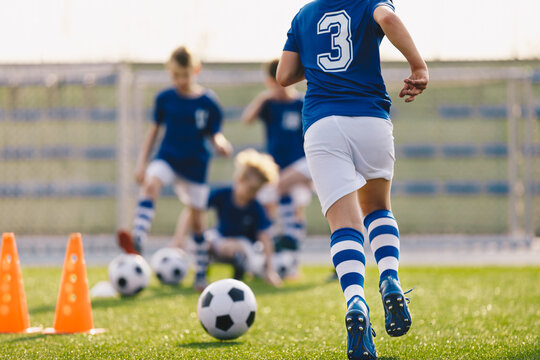 Boy Running on Grass Field in Soccer Cleats. Closeup image on Football Shoes.  Young Boy in Turf Boots for Playing Football on Natural and Artificial Ground