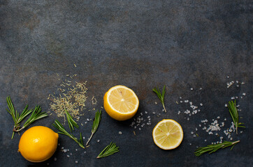 Top view of juicy lemons, fresh and dry rosemary, sea salt.Ingredients for cocktails and meal.Empty space