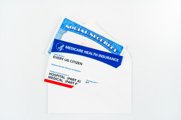 Every us citizen text on blank medicare health card with social security card in envelope isolated on white.