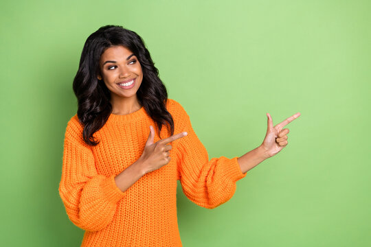 Portrait of attractive curious cheerful girl demonstrating ad copy space new novelty isolated over green pastel color background