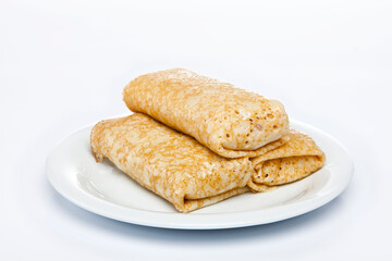 Rolled stuffed pancake on white plate 