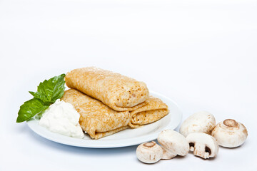 Rolled stuffed pancake on white plate 