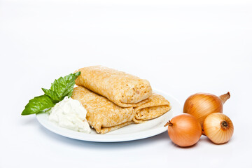 Rolled stuffed pancake on white plate 