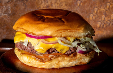 Gourmet Cheese Burger on special bread and beer on wooden table