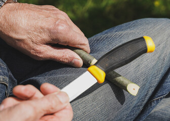 An old man making a willow flute for his grand-children.