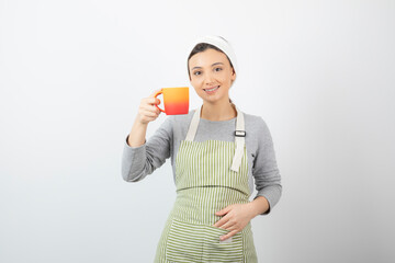 Image of a pretty young woman in apron holding a cup