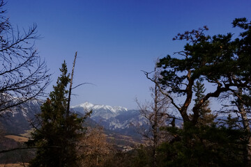 standing on the summit from a mountain with view to other mountains with snow