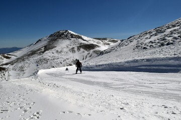 Ski trail in a ski resort and skier