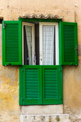 Fototapeta na wymiar window ith green shutters in old town in calabria