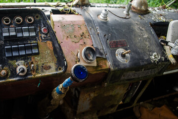 Rusty, old abandoned bus cab with front panel and blue gearbox shifter in Latvia