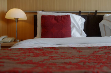 Bedroom of balcony suite cabin stateroom in clean modern cozy interior design in creme and red on...