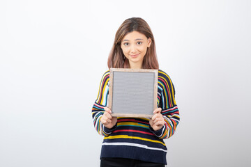 Photo of a young girl model standing and holding a frame