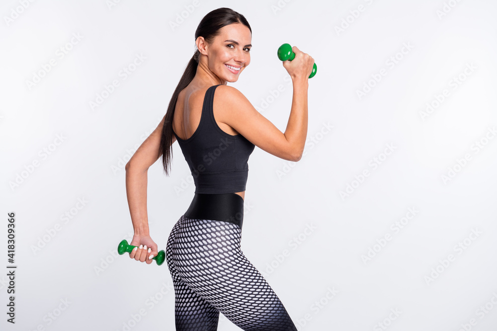 Poster back rear spine view photo of charming happy lady hold dumbbells good mood smile isolated on grey co