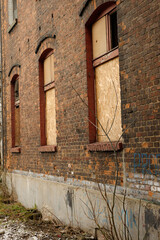 zabite deskami otwory okienne w kamienicy