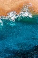 Beautiful sandy beach with blue sea, vertical view. Drone view of tropical blue ocean beach Nusa penida Bali Indonesia. Lonely sandy beach with beautiful waves. Beaches of Indonesia. Copy space