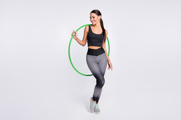 Full length photo of attractive pretty young woman hold hula hoop gym active isolated on grey color background - Powered by Adobe