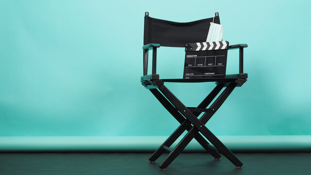 BLACK Director Chair With Clapperboard Or Movie Clapper Board And Face Mask On Green Or Tiffany Blue And Black Floor Background.it Use In Video Production Or Movie And Cinema Industry.