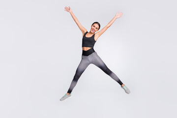 Full length photo of charming cheerful young woman jump up star shape sportive isolated on grey color background