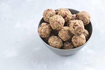 Homemade energy balls made from dried fruits and oatmeal. Healthy food, snack. Vegetarian, vegan raw dessert. Energy balls in a bowl on a gray background. Copy space