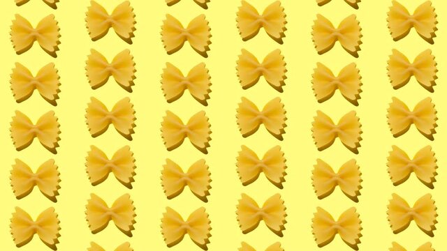 Stop motion animation raw italian pasta farfalle made from third grade wheat moving up and down on yellow background