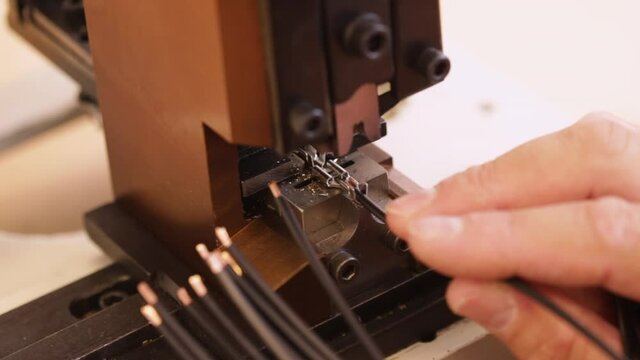Hand apply wire connector terminals to electric wires using a crimping machine - close up, static camera